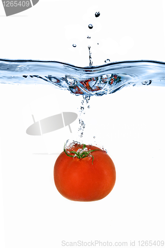 Image of red tomato dropped into water isolated on white