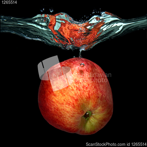 Image of green apple dropped into water with splash isolated on black