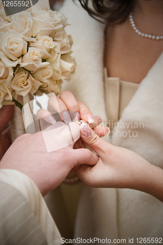 Image of puttting on a wedding ring. natural photo