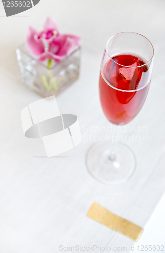 Image of red alcohol cocktail in glass with orchid