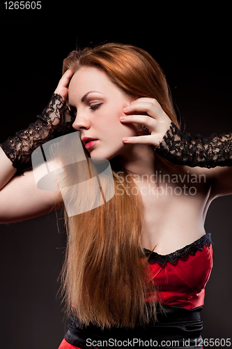 Image of Attractive sexy woman with red long hair on black