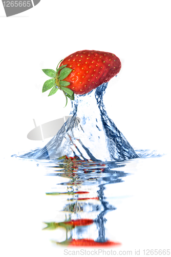Image of Fresh strawberry dropped into blue water with splash isolated on
