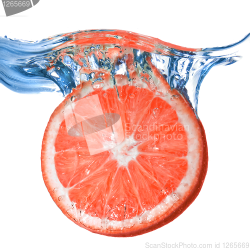 Image of Fresh grapefruit dropped into water with bubbles isolated on whi