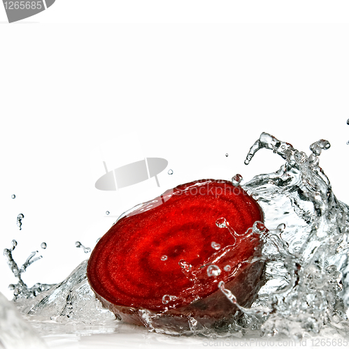 Image of red beet with water splash isolated on white