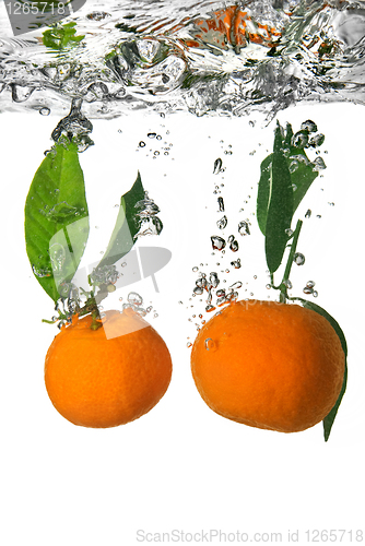 Image of tangerine dropped into water with bubbles on white