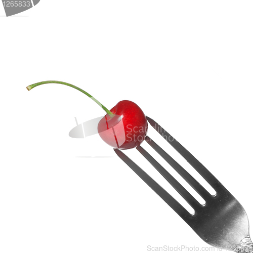 Image of red cherry on fork isolated on white