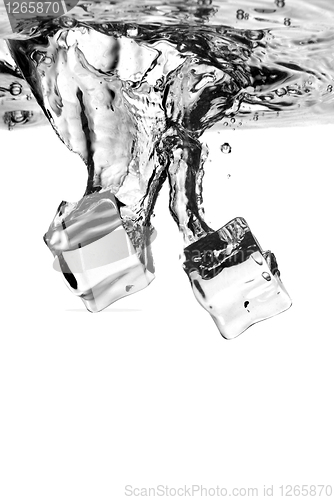 Image of ice cubes dropped into water with splash isolated on white