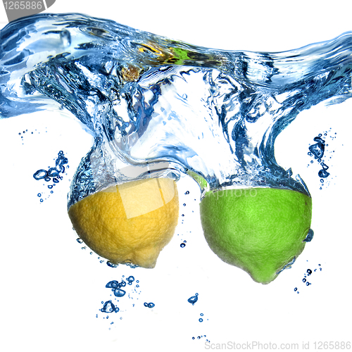 Image of lemon and lime dropped into water with bubbles isolated on white