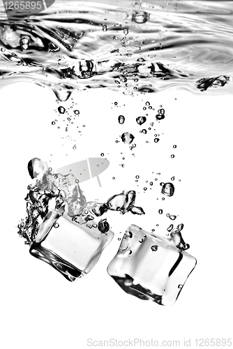 Image of ice cubes dropped into water with splash isolated on white