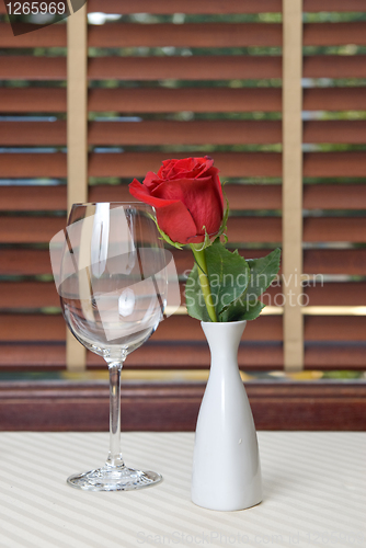 Image of wineglass and rose on the table