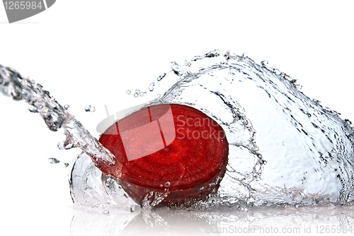 Image of red beet with water splash isolated on white