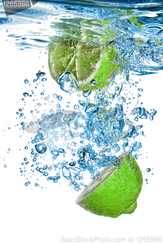 Image of Fresh lime dropped into water with bubbles isolated on white