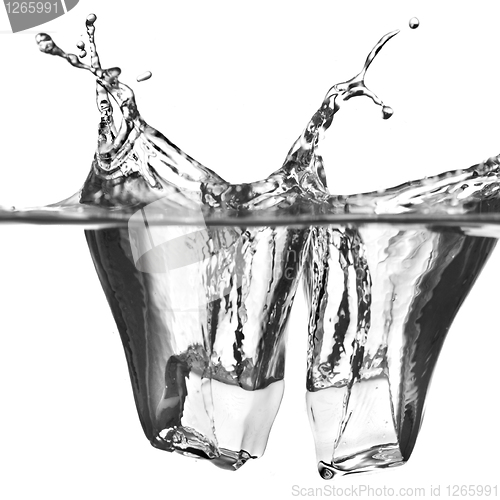 Image of ice cubes dropped into water with splash isolated on white