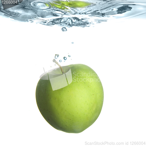 Image of green apple dropped into water with bubbles isolated on white