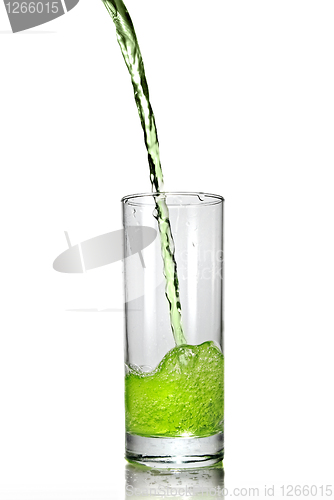 Image of green juice pouring into glass isolated on white