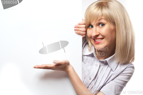 Image of Attractive smiling woman holding white empty paper isolated on w