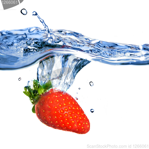 Image of Fresh strawberry dropped into blue water with splash isolated on