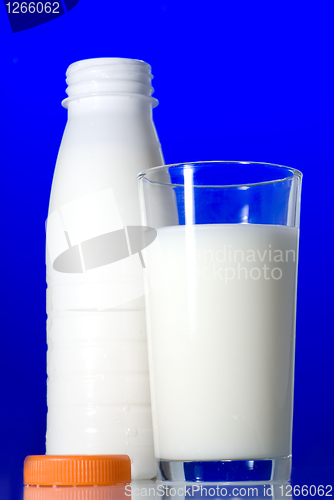Image of Milk in glass and open bottle isolated on blue