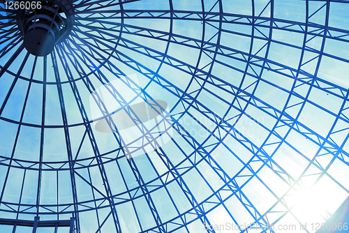 Image of Modern glass roof with blue sky and sun