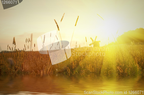 Image of field on sunset with water reflection