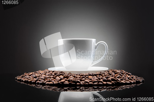 Image of white cup with coffee beans on black