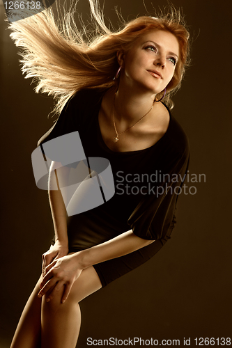 Image of Portrait of attractive young smiling woman on black