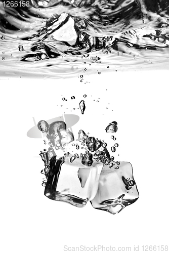 Image of ice cubes dropped into water with splash isolated on white