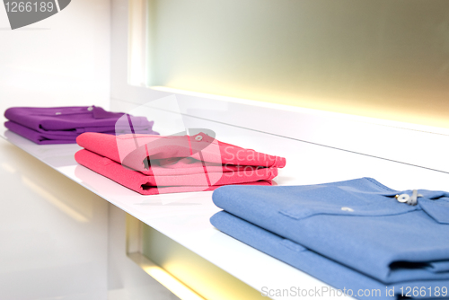 Image of white store shelf with color clothes