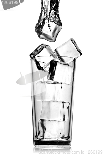 Image of ice cubes dropped into glass with bubbles isolated on white