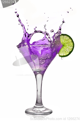 Image of Violet alcohol cocktail with splash and green lime isolated on w