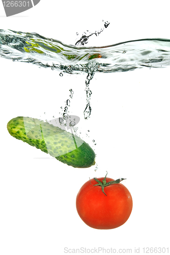 Image of red tomato and green cucumber dropped into water isolated on whi