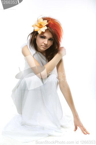 Image of Portrait of beautiful woman with spring flower in hair on white