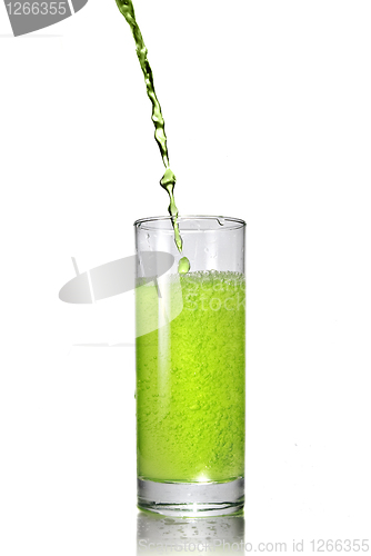 Image of green juice pouring into glass isolated on white