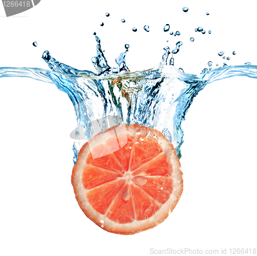 Image of Fresh grapefruit dropped into water with bubbles isolated on whi