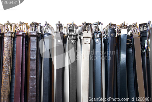 Image of a lot of leather belts in store isolated on white