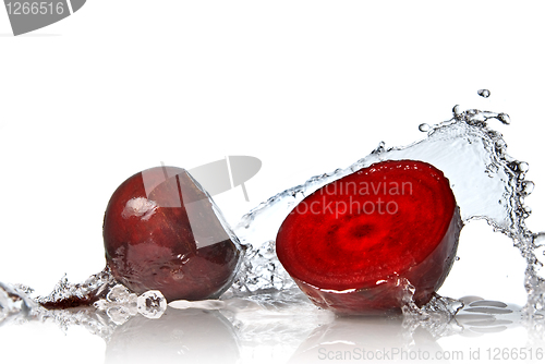 Image of red beet with water splash isolated on white