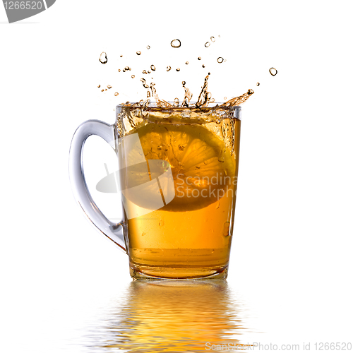 Image of lemon dropped into tea cup with splash and reflection isolated o