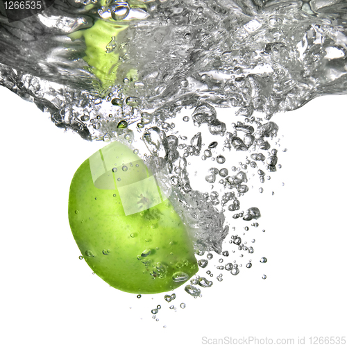 Image of green apple dropped into water isolated on white