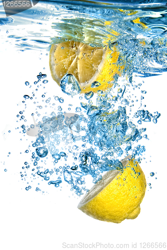Image of Fresh lemon dropped into water with bubbles isolated on white