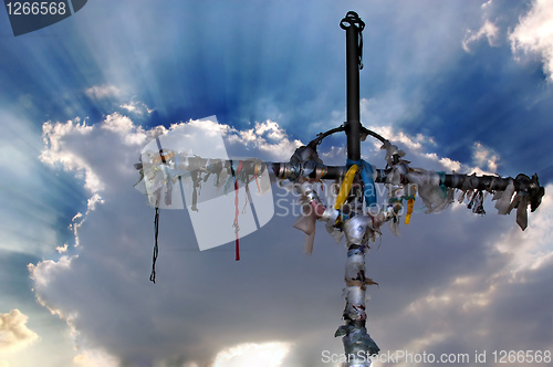 Image of Cross with ribbons against clouds