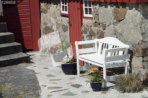 Image of White bench and old house