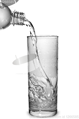 Image of water pouring into glass from bottle isolated on white
