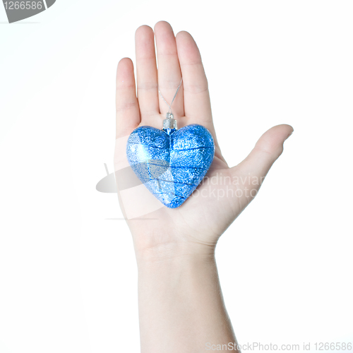 Image of arm holding blue christmas ball in shape of heart isolated on wh