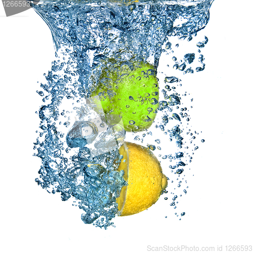 Image of lemon and lime dropped into water with bubbles isolated on white
