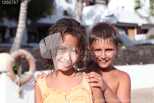 Image of boy and girl playing near pool