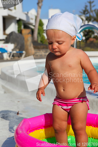 Image of baby girl playing in a colorful kiddie pool