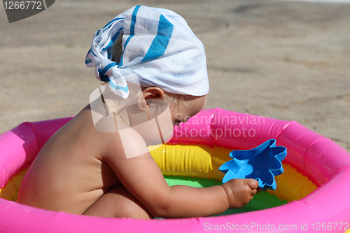 Image of baby girl playing in a colorful kiddie pool
