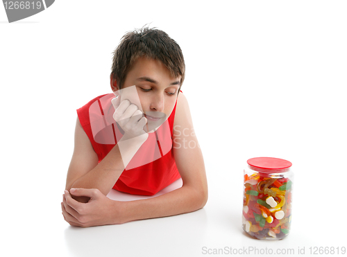 Image of Boy ponders to open jar confectionery