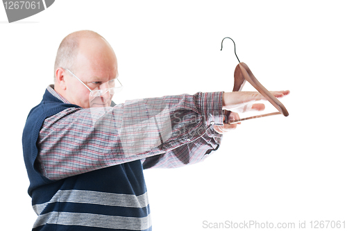 Image of Confident man in glasses measures by hand empty cloth hanger