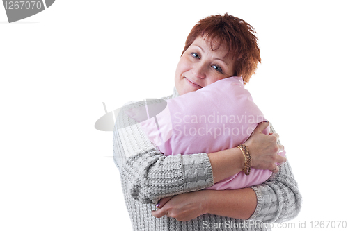 Image of Smiling woman hugs pink pillow